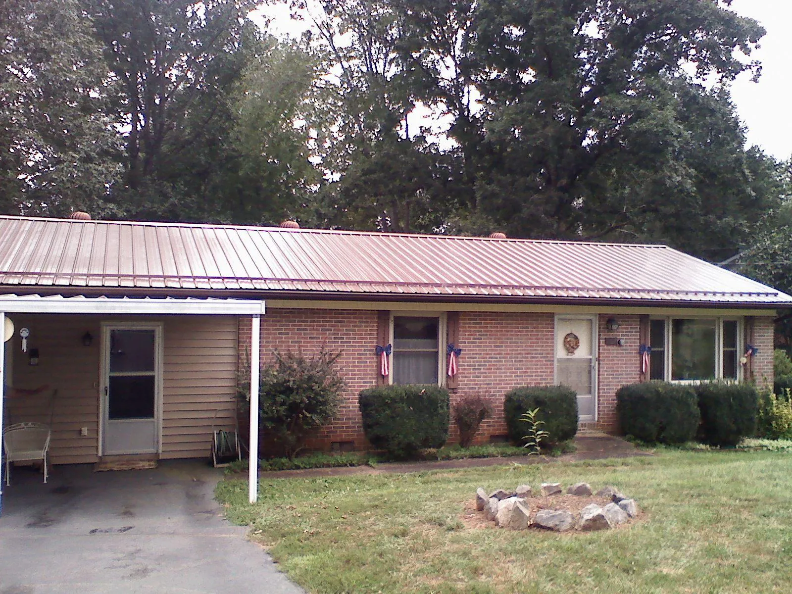 Bronze metal roof and carport on a brick ranch home — Roof Repair work by our crew in Duvall